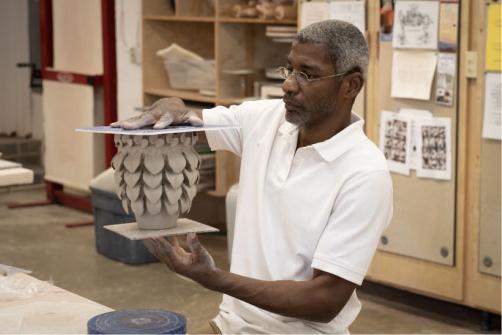 man holding ceramic pottery